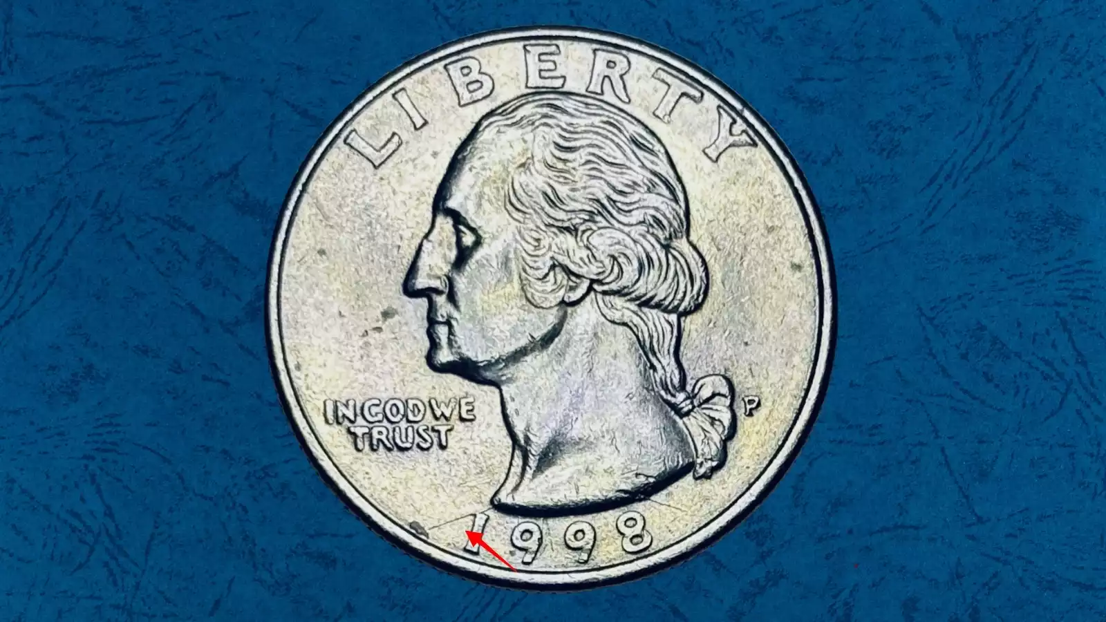 1998 quarter broadstrike error showing expanded diameter wider than normal with smooth edge and design spreading toward rim, compared to normal quarter